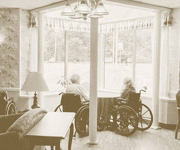 Women in wheelchairs looking out of window at Carrier Mills WLC facility