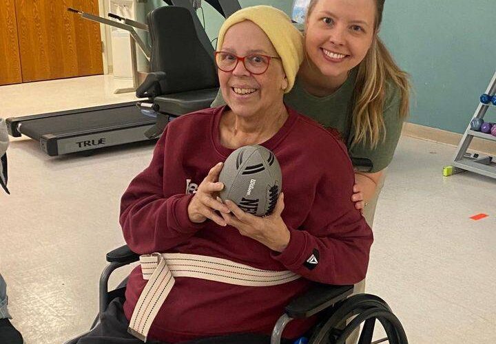 resident at wabash senior living holding a football with nurse