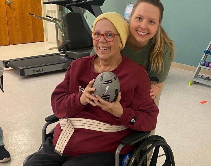 resident at wabash senior living holding a football with nurse